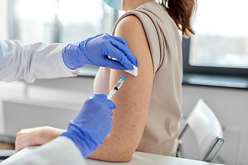 Image showing female doctor with syringe vaccinating patient