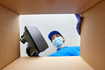 Image showing woman in mask packing vr glasses to parcel box