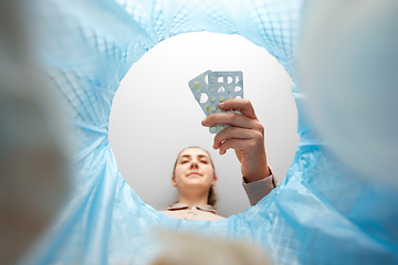 Image showing woman throwing old medicine pills into trash can