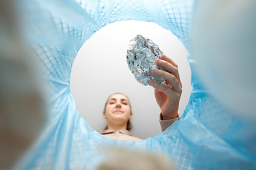 Image showing woman throwing crumpled foil into trash can