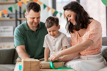 Image showing happy family opening birthday presents at home