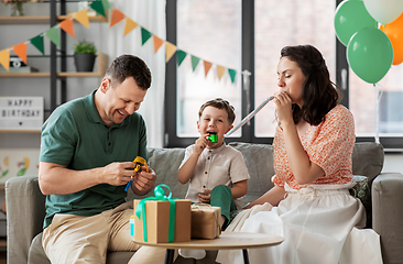 Image showing happy family with gifts and party blowers at home