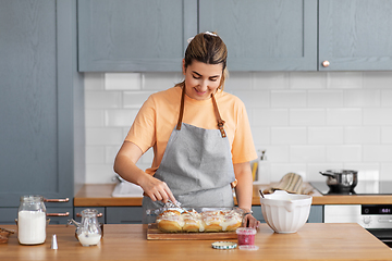 Image showing woman cooking food and baking buns at home kitchen