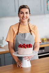 Image showing happy woman with raspberry cake on kitchen at home