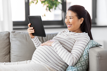 Image showing happy pregnant asian woman with tablet pc at home