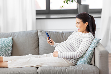 Image showing happy pregnant woman with smartphone at home