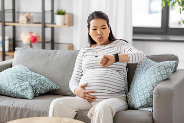 Image showing pregnant woman having labor contractions at home