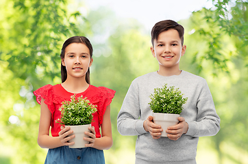 Image showing happy smiling children holding flower in pot