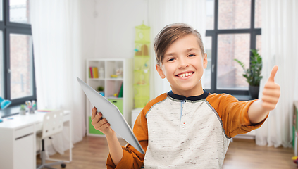 Image showing smiling boy with tablet showing thumbs up at home