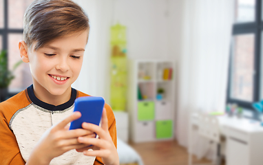 Image showing boy with smartphone texting or playing at home