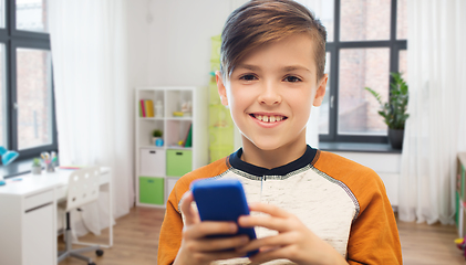 Image showing boy with smartphone texting or playing at home