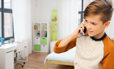 Image showing happy boy calling on smartphone at home