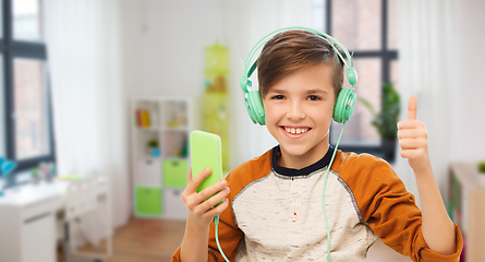 Image showing happy boy with smartphone and headphones at home