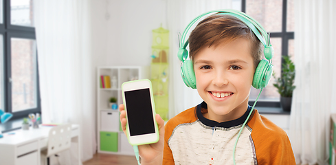 Image showing happy boy with smartphone and headphones at home