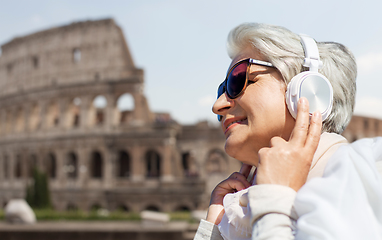 Image showing old woman in headphones listens to music in rome