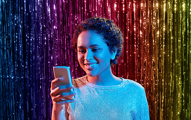 Image showing african woman with smartphone at party
