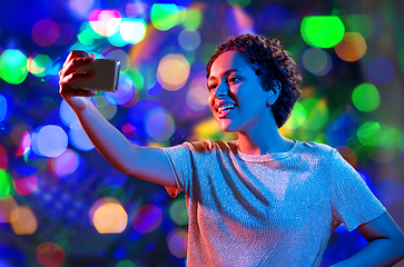 Image showing woman taking selfie with smartphone in neon lights