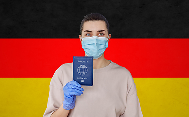 Image showing woman in mask and gloves holding immunity passport