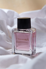 Image showing bottle of perfume on white sheet