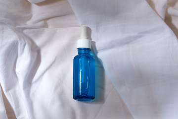 Image showing bottle of serum on white sheet