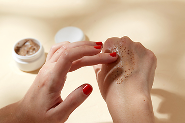 Image showing close up of hands applying natural scrub to skin