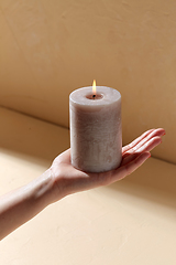 Image showing hand holding burning aroma candle on palm