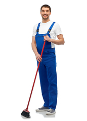 Image showing male cleaner in overall cleaning floor with broom