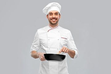 Image showing smiling male chef with frying pan cooking food