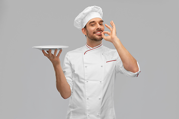Image showing happy smiling male chef holding empty plate