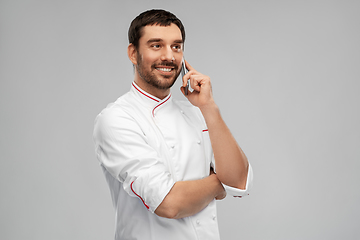 Image showing happy smiling male chef calling on smartphone