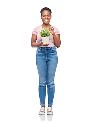 Image showing happy smiling african woman holding flower in pot