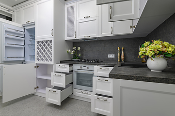 Image showing Open doors and drawers open at modern white kitchen