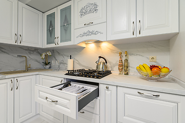 Image showing Open drawers with kitchenware at modern white kitchen