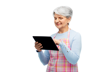 Image showing smiling senior woman in apron with tablet computer