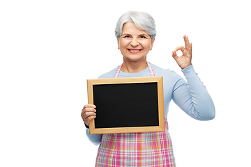 Image showing senior woman in apron with chalkboard showing ok