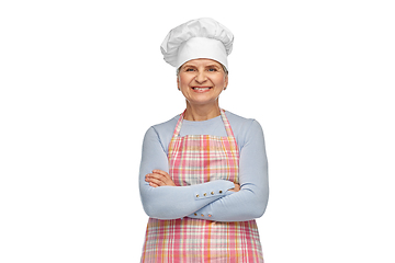 Image showing smiling senior woman or chef in toque in apron