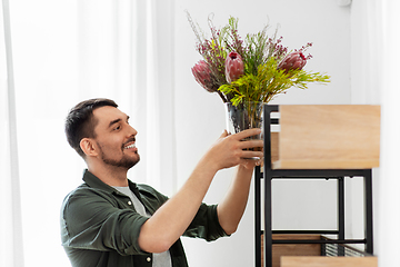 Image showing man decorating home with flower or houseplant