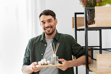 Image showing man placing aroma reed diffuser to shelf home