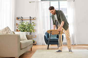 Image showing man placing coffee table next to sofa at home