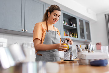 Image showing happy young woman cooking food on kitchen at home