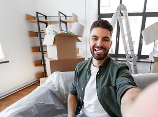 Image showing man having video call and moving into new home