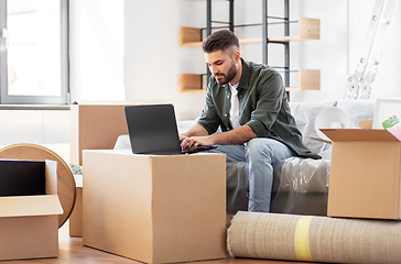 Image showing man with laptop computer and moving into new home