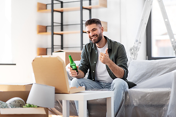 Image showing man with box of pizza and beer bottle at new home