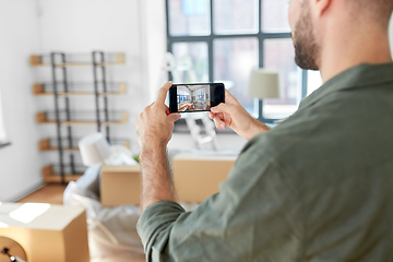 Image showing man with smartphone taking picture of new home