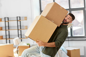 Image showing man holding heavy boxes and moving to new home