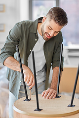 Image showing happy man assembling coffee table at new home