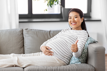 Image showing happy pregnant asian woman showing thumbs up