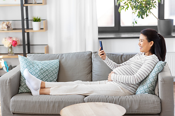 Image showing happy pregnant woman with smartphone at home