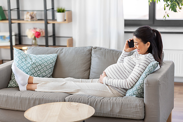 Image showing happy pregnant woman calling on smartphone at home