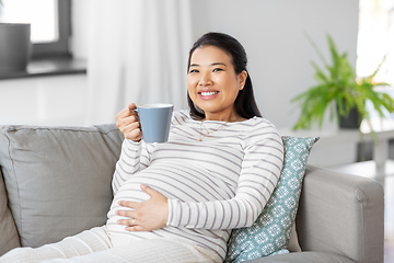 Image showing happy pregnant woman drinking tea at home